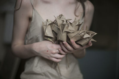Midsection of woman holding paper craftwork