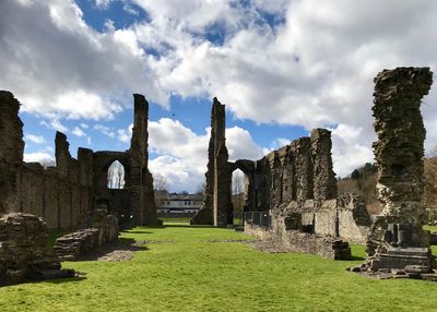 View of old ruin on field against cloudy sky