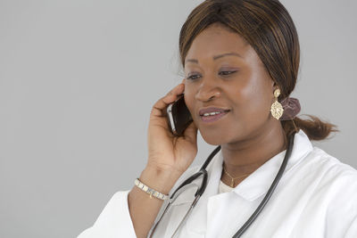 Close-up of mid adult woman against white background