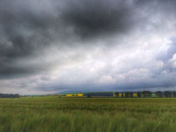 Scenic view of field against cloudy sky