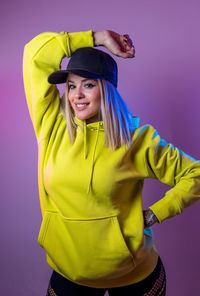 Portrait of smiling young woman against gray background