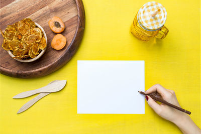 High angle view of hand on cutting board on table