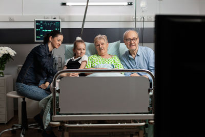 Cheerful family watching movie at hospital