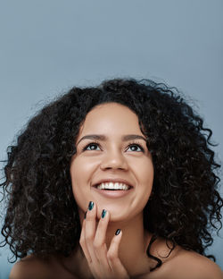 Portrait of young woman against blue background