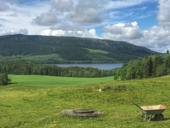 Scenic view of green landscape and mountains against sky