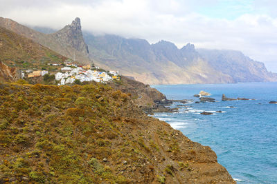 Scenic view of sea and mountains against sky