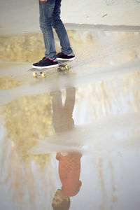 Low section of person standing in water