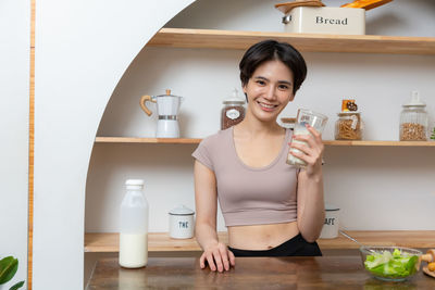 Portrait of young woman drinking glass