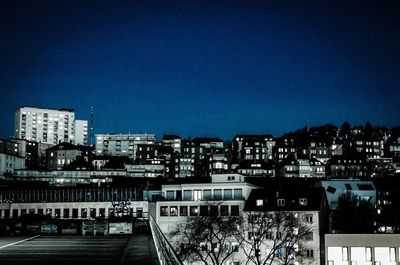 Illuminated cityscape against clear sky at night