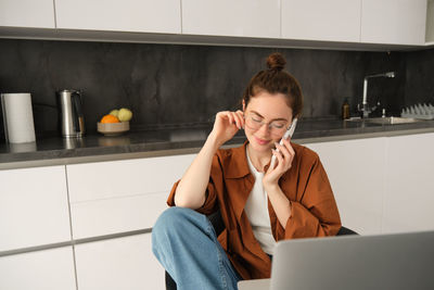 Young businesswoman using laptop at home