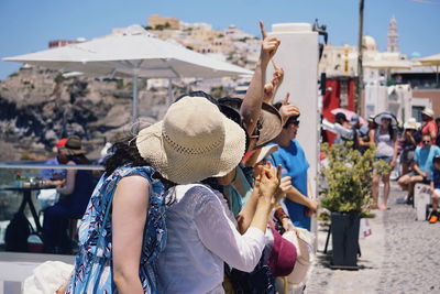 Midsection of woman photographing with mobile phone in city