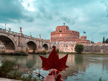 Arch bridge over lake against sky during autumn