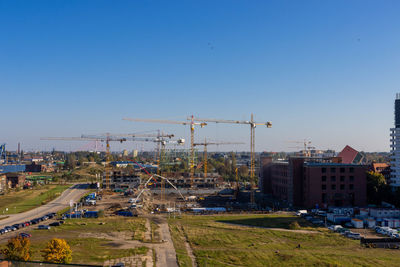 Construction site in city against clear blue sky