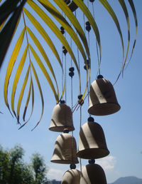 Low angle view of lighting equipment hanging against sky