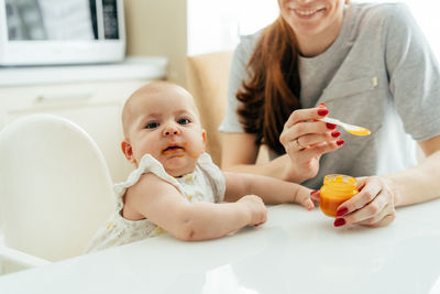 Portrait of cute baby girl sitting on table