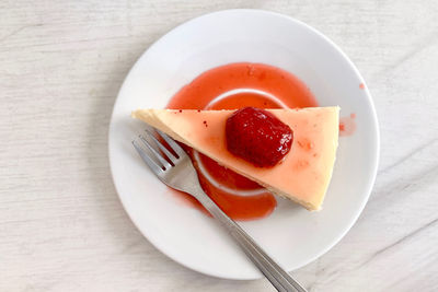 High angle view of food in plate on table, strawberry cheese cake