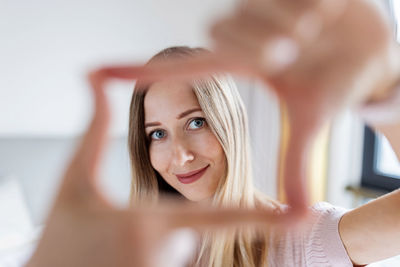 Portrait of smiling woman looking through fingers