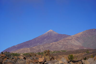 Scenic view of mountains against clear blue sky