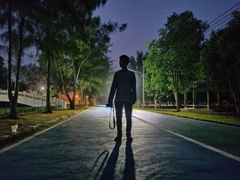 Rear view of man walking on footpath in city