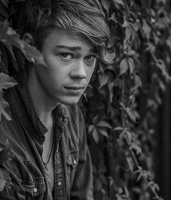 Close-up portrait of boy standing by plants