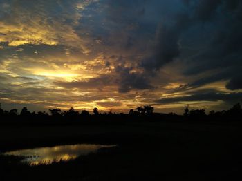 Scenic view of silhouette landscape against dramatic sky during sunset