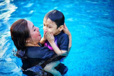 Mother and daughter swimming in pool