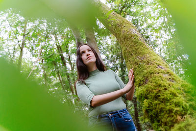 Young woman smiling against trees