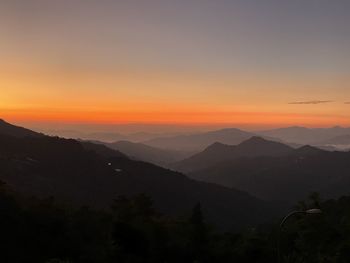 Scenic view of silhouette mountains against sky at sunset