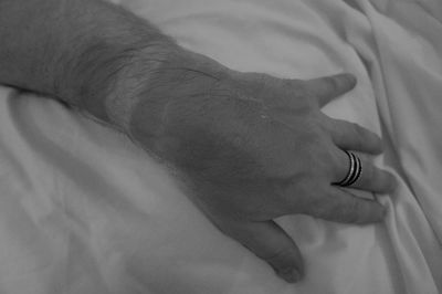 Close-up of woman hand on bed