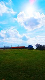 Scenic view of grassy field against cloudy sky