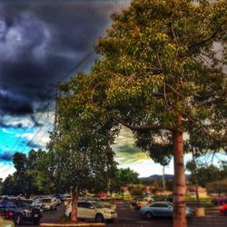 Cars on road against cloudy sky