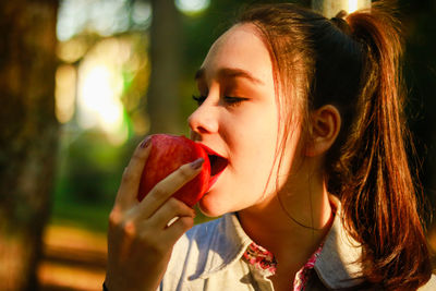 Close-up of young woman eating apple