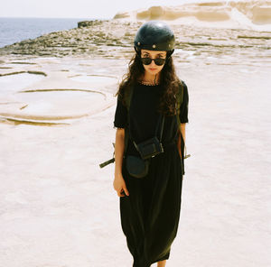 Woman wearing sunglasses standing on beach