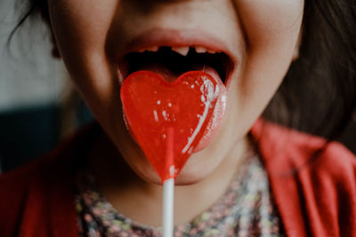 Close-up of woman with red heart shape