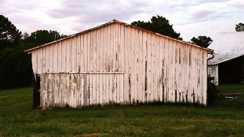 Barn on field against sky