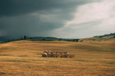 Hay bales on field against sky