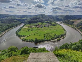 High angle view of river by mountain against sky