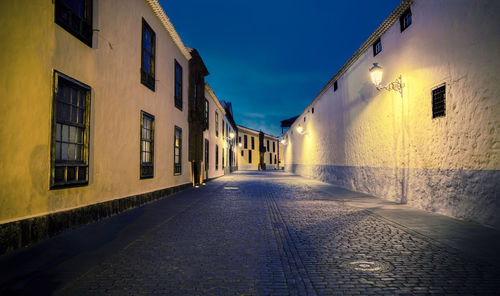 Empty road along buildings