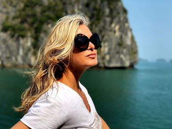 Woman wearing sunglasses against sea