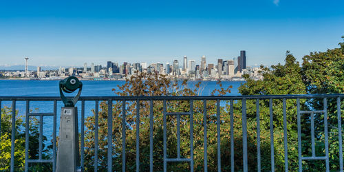 A telescope points toward the seattle skyline.