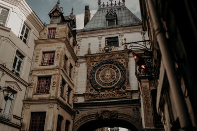 Low angle view of clock tower amidst buildings in city