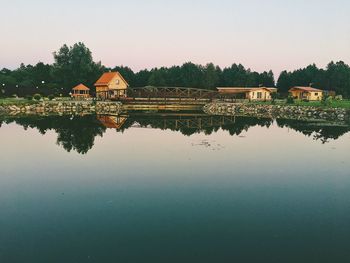 Reflection of building in lake against clear sky