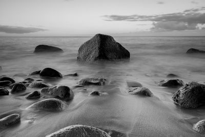 Rocks on beach against sky