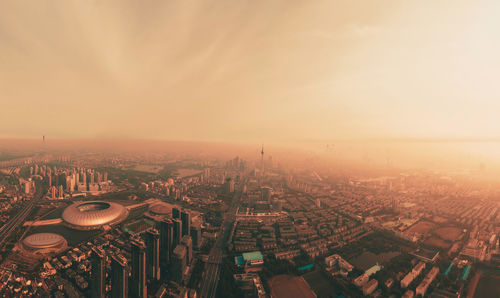 Aerial view of buildings in city against sky during sunset