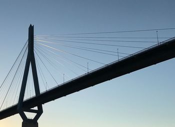 Low angle view of suspension bridge against clear sky