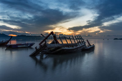 Ship moored on sea against sky during sunset