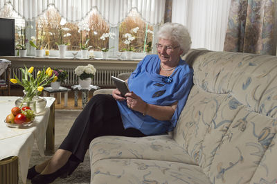 80 year old risk group for corona. she reads e book reader and distracts herself from the worries.