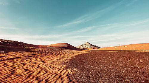 Sand dunes in desert against sky