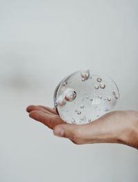 Close-up of man holding hands over white background