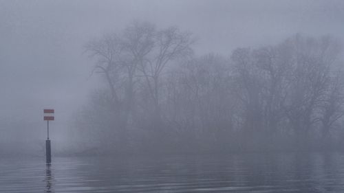 Scenic view of lake against sky during foggy weather
